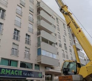 Pendant le grutage des matériaux sur le toit terrasse de l'immeuble de la résidence